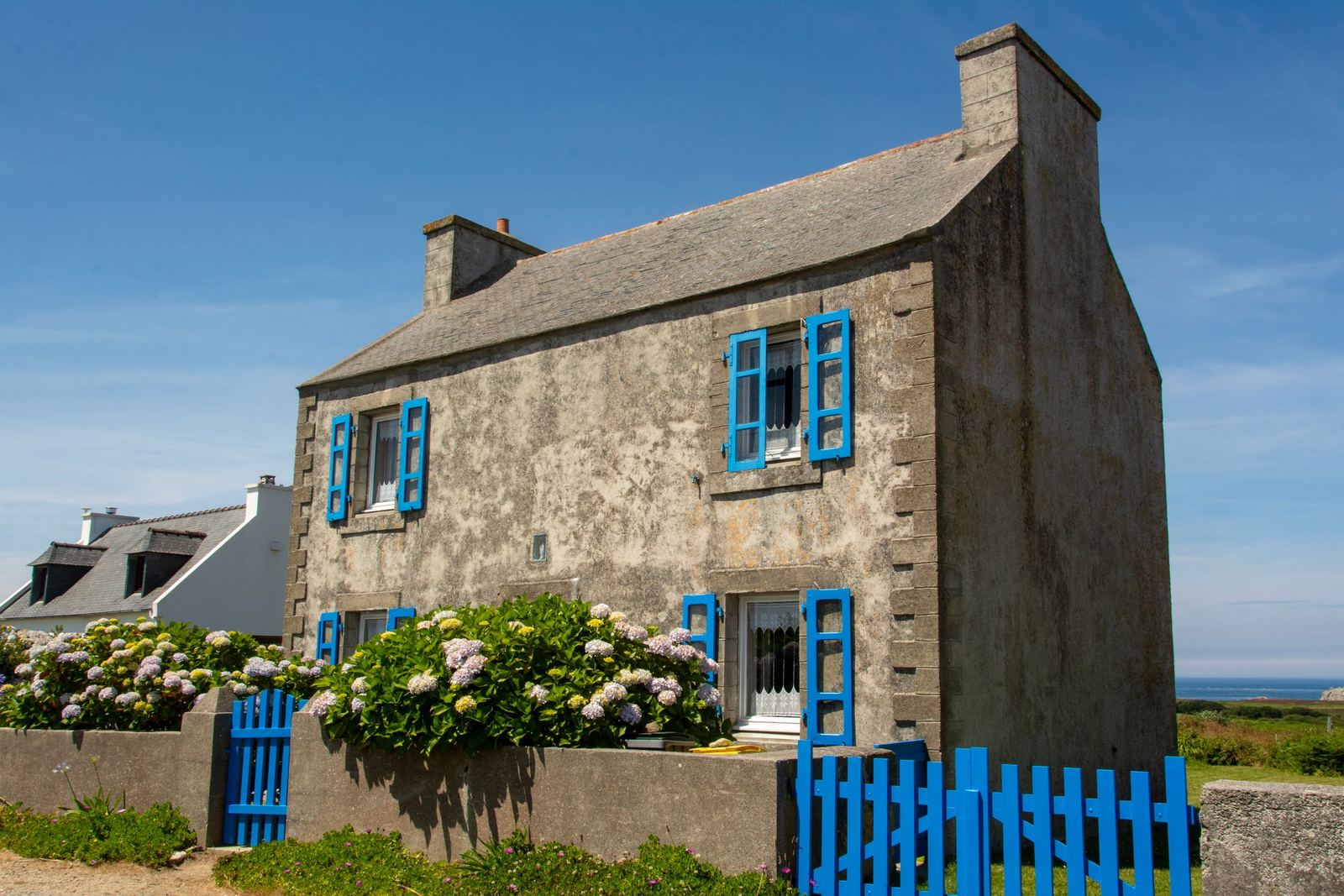 Maison bretonne en pierre avec toiture en ardoise et volets bleus